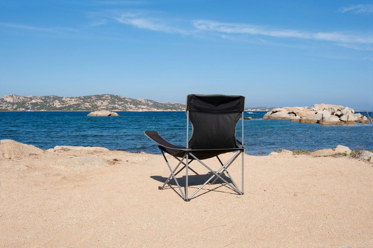 Solstol på en strand som illustrerer ferie og feriepenger