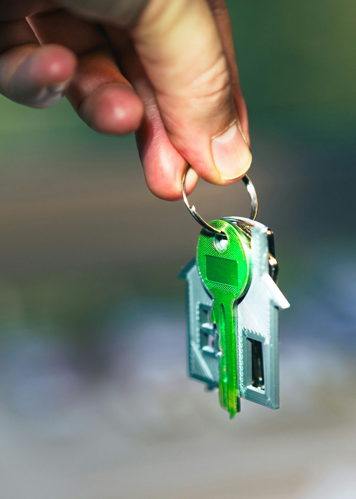 Hand holder en nokkel til et hus