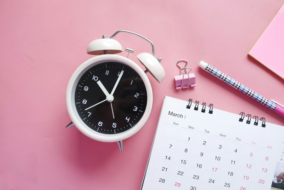 Vekkerklokke ved siden av en kalender som symbol pa en ny frist