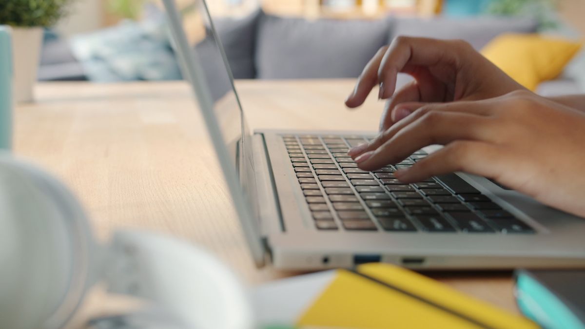 Hender som skriver pa et tastatur ved et skrivebord